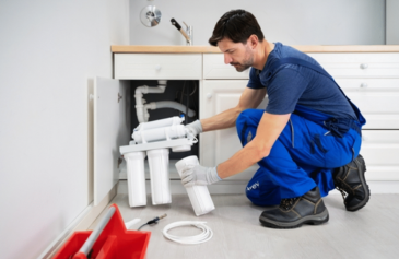 Technician installing a wall-mounted RO water purifier